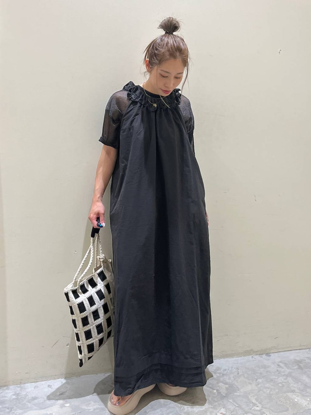 ベージュ系のサンダル、ブラック系のワンピース、ブラック系のトートバッグを着用したレディースの春コーディネートの3枚目の写真