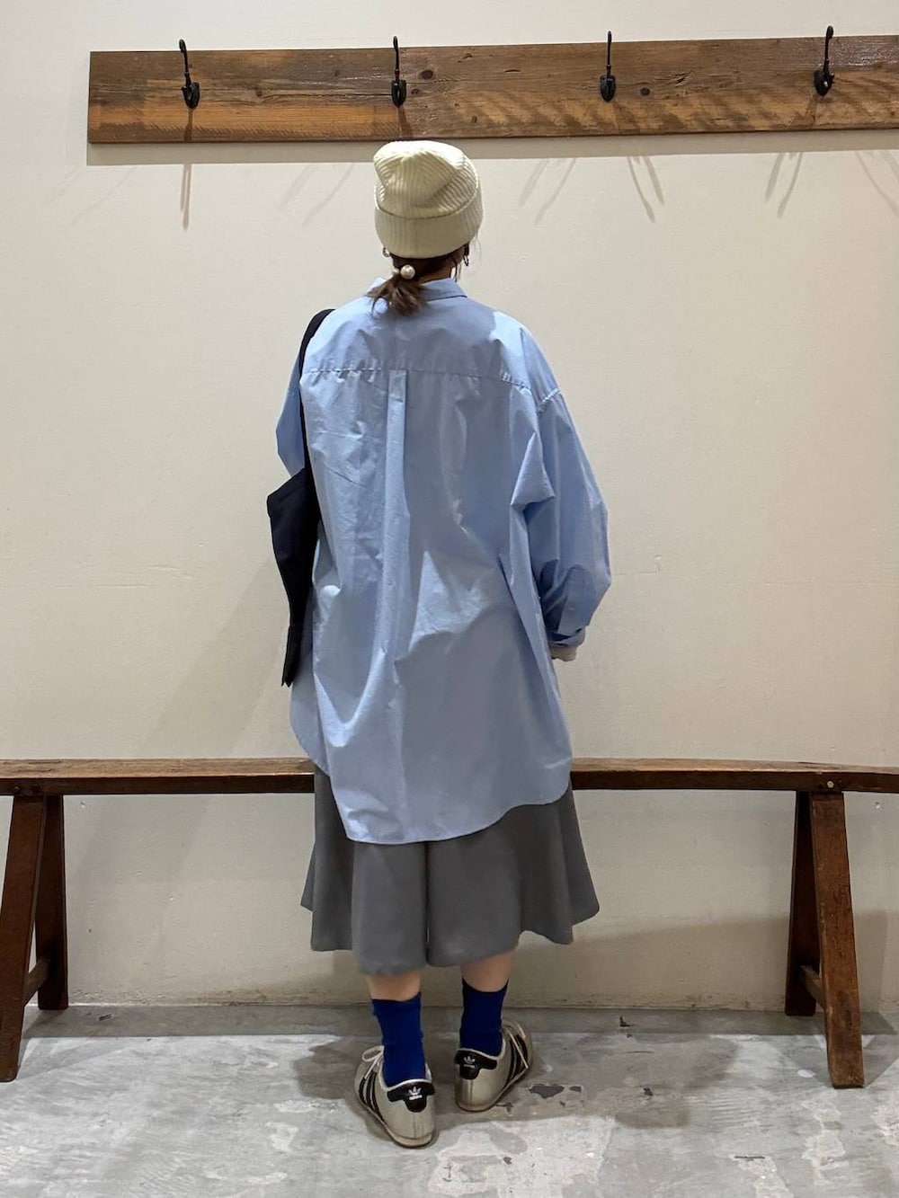 ブルー系のトートバッグ、ゴールド系のスニーカー、ベージュ系のTシャツ/カットソーを着用したレディースの冬コーディネートの5枚目の写真