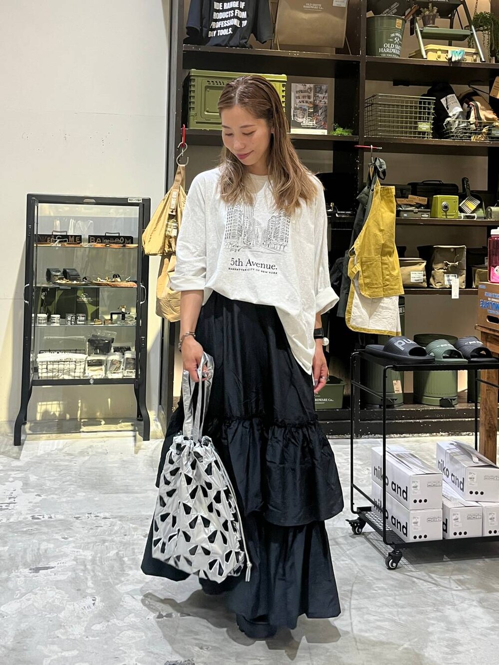 ベージュ系のTシャツ/カットソー、その他のトートバッグ、ブラック系のスカートを着用したレディースの夏コーディネートの6枚目の写真