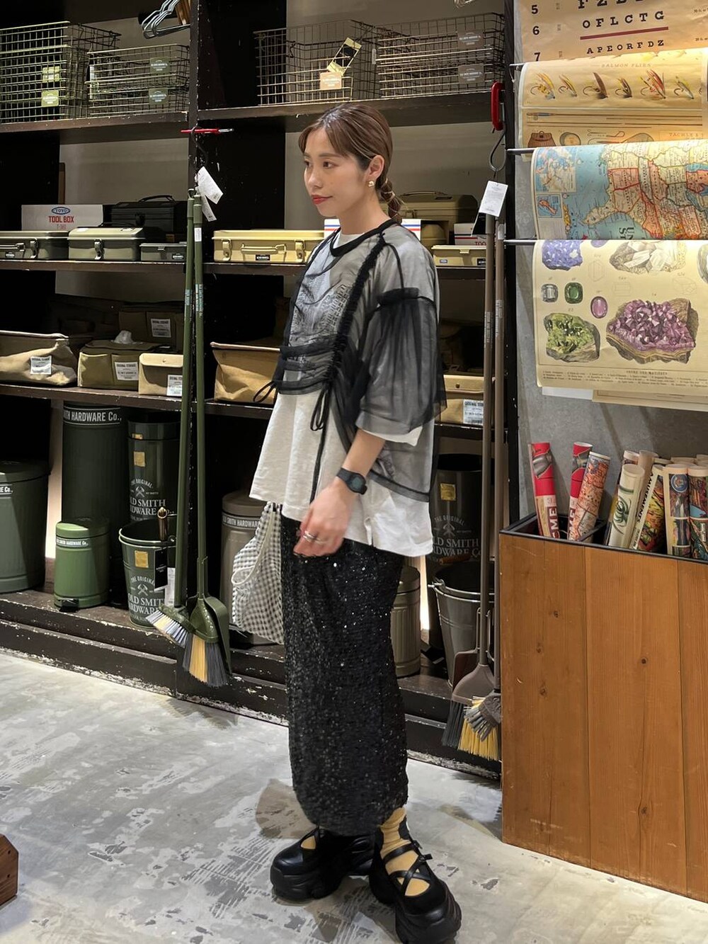 ブラック系のスニーカー、ブラック系のスカート、ベージュ系のTシャツ/カットソーを着用したレディースの春コーディネートの5枚目の写真