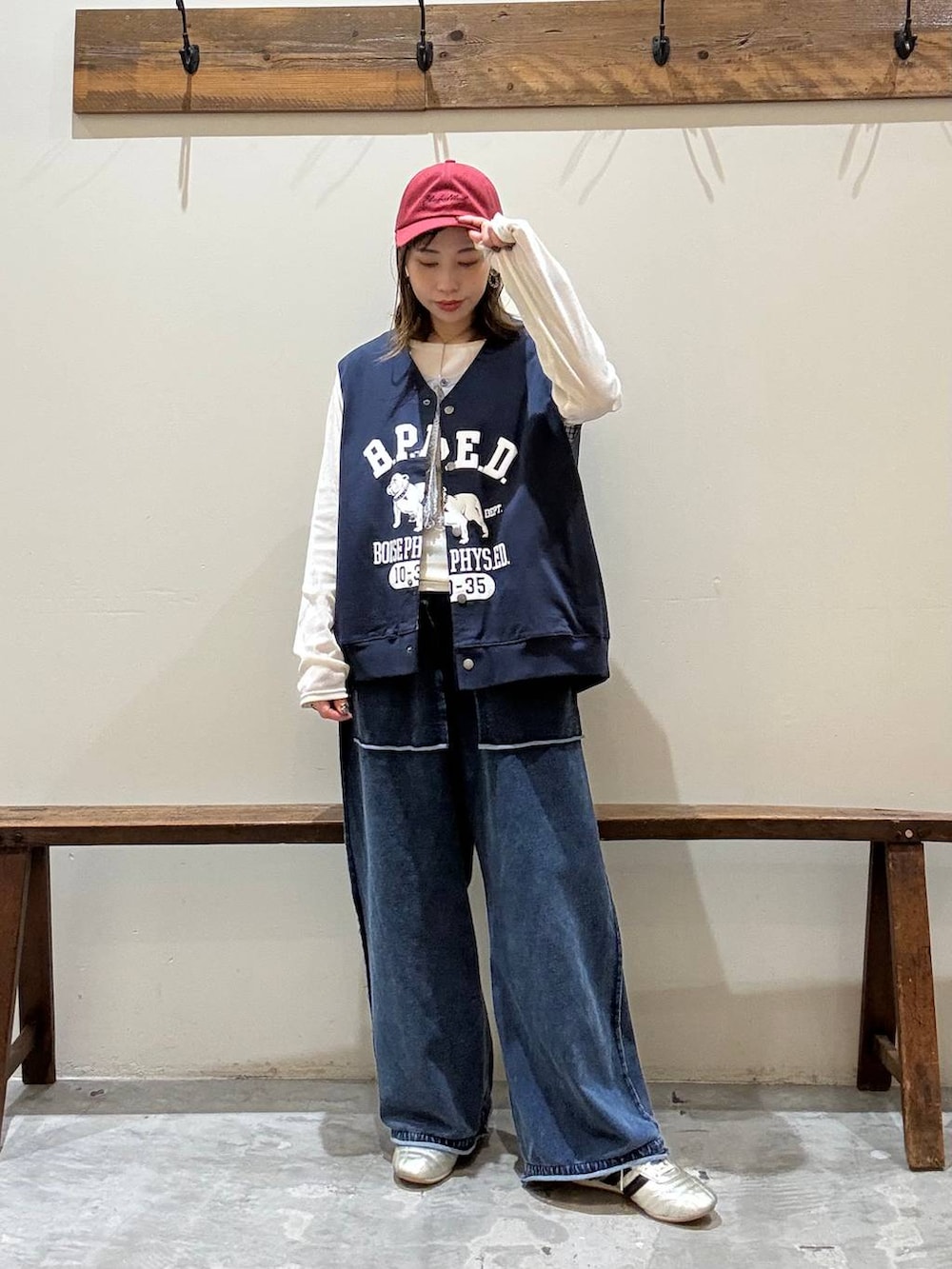 ゴールド系のスニーカー、ベージュ系のTシャツ/カットソー、ブルー系のベストを着用したレディースの冬コーディネートの4枚目の写真