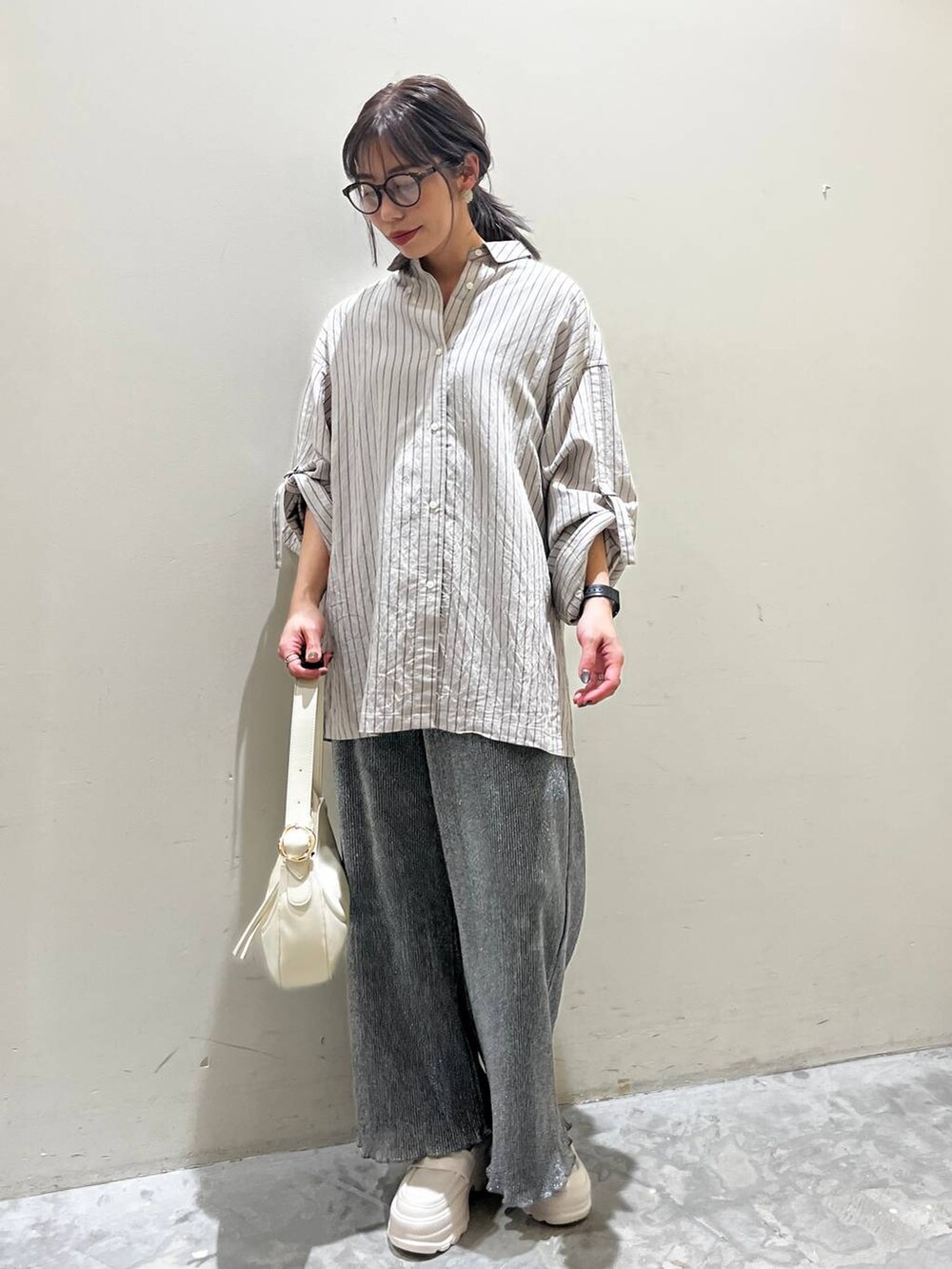 ベージュ系のショルダーバッグ、ベージュ系のローファー、グレー系のその他パンツを着用したレディースの春コーディネートの5枚目の写真