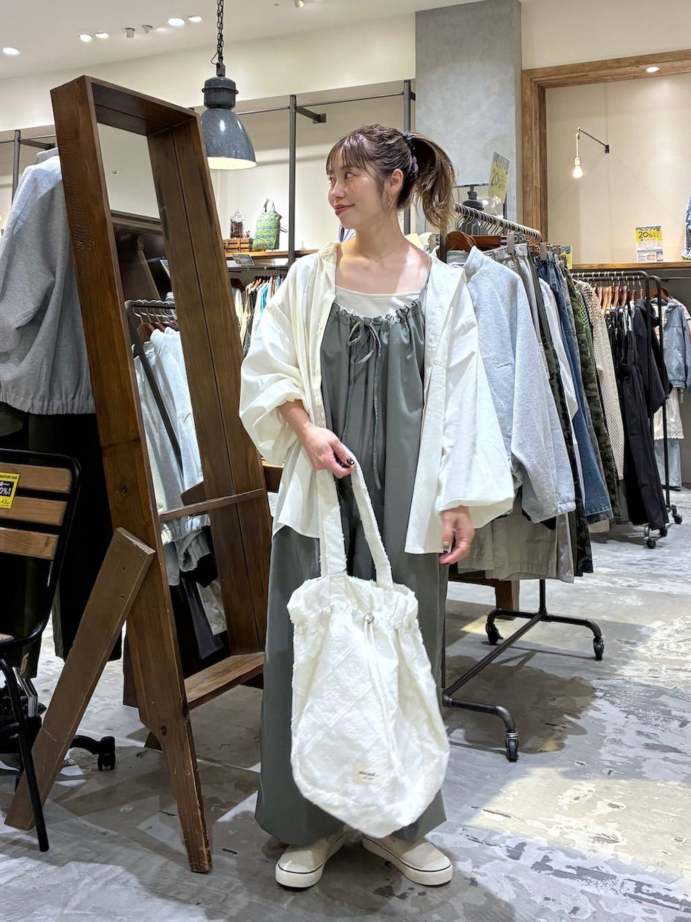 グリーン系のサロペット/オーバーオール、ホワイト系のシャツ/ブラウス、ベージュ系のタンクトップを着用したレディースの春コーディネートの2枚目の写真