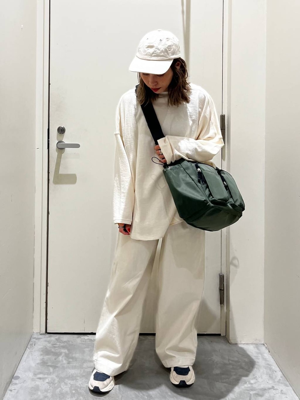 ベージュ系のその他パンツ、ベージュ系のTシャツ/カットソー、グリーン系のショルダーバッグを着用したレディースの冬コーディネートの4枚目の写真