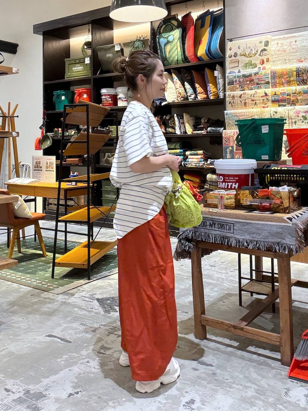 オレンジ系のその他パンツ、オレンジ系のTシャツ/カットソー、イエロー系のショルダーバッグを着用したレディースの春コーディネートの3枚目の写真