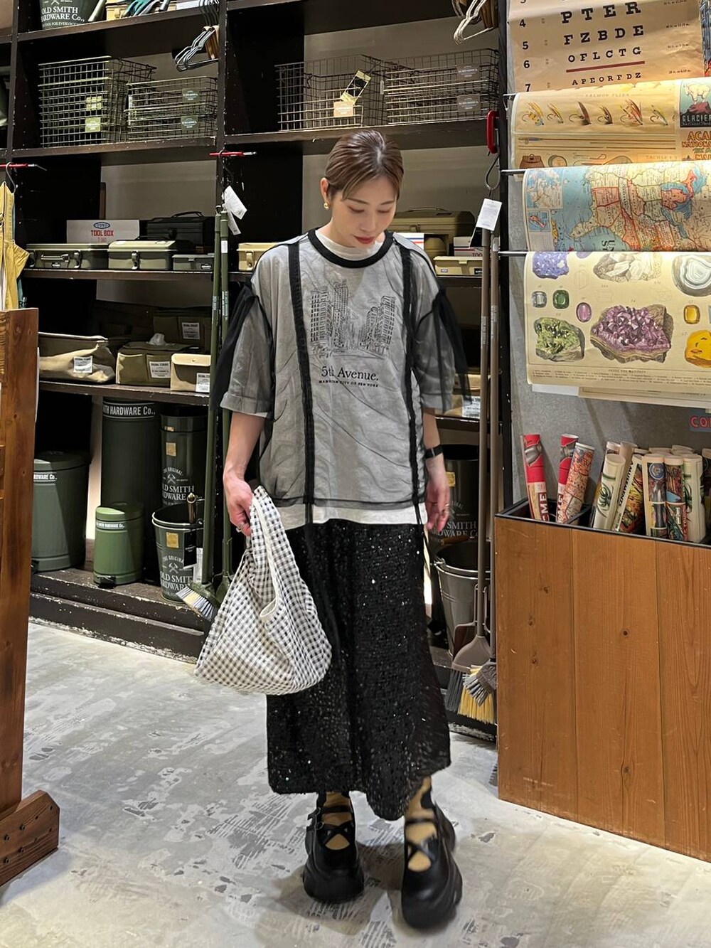 ブラック系のスニーカー、ブラック系のスカート、ベージュ系のTシャツ/カットソーを着用したレディースの春コーディネートの2枚目の写真