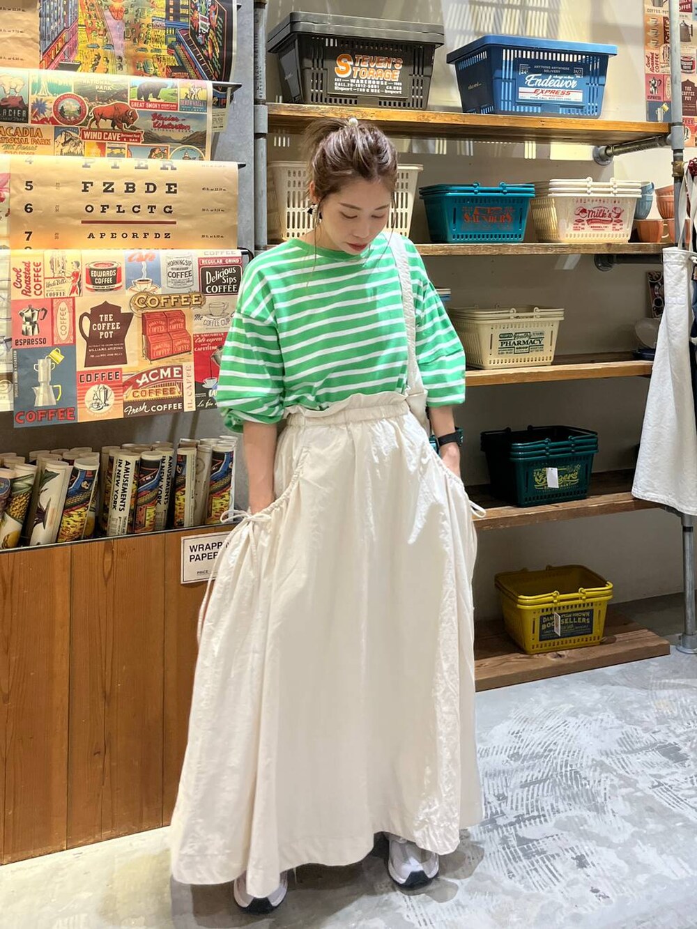 ベージュ系のスカート、ホワイト系のショルダーバッグ、グリーン系のTシャツ/カットソーを着用したレディースの春コーディネートの10枚目の写真