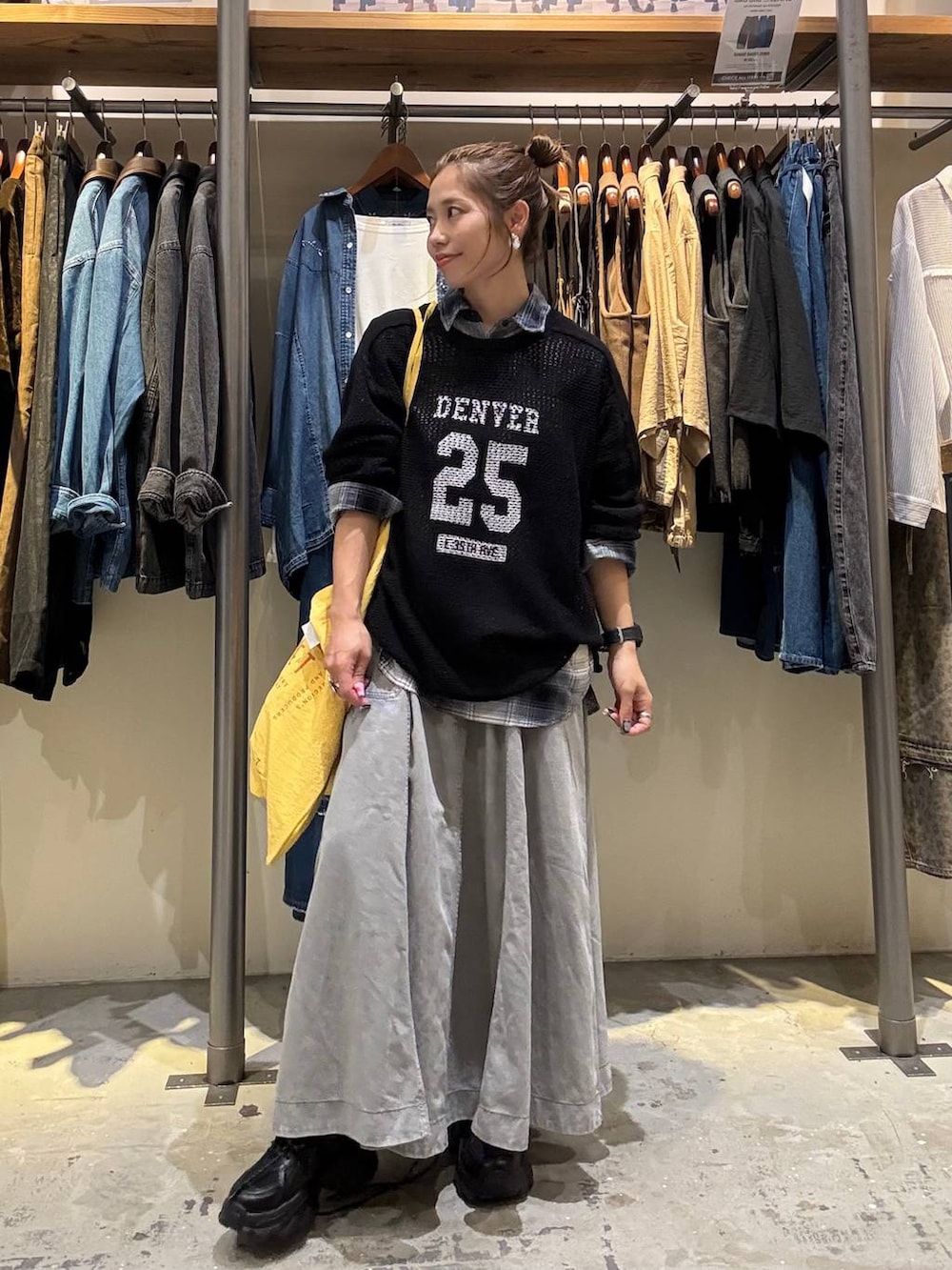 イエロー系のトートバッグ、グレー系のスカート、ブラック系のスニーカーを着用したレディースの秋コーディネートの3枚目の写真