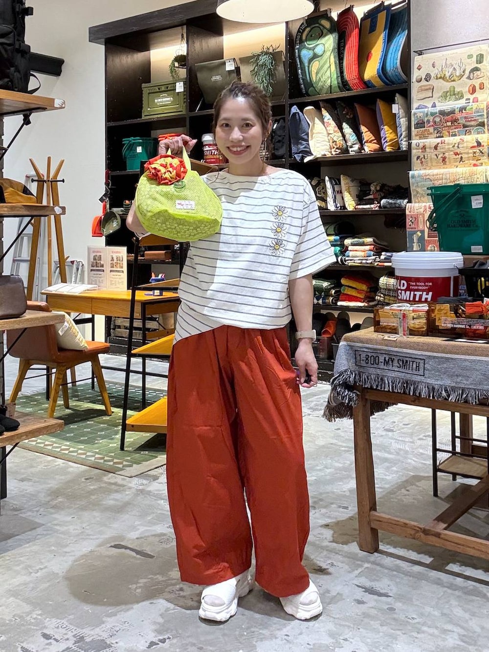 オレンジ系のその他パンツ、オレンジ系のTシャツ/カットソー、イエロー系のショルダーバッグを着用したレディースの春コーディネートの2枚目の写真