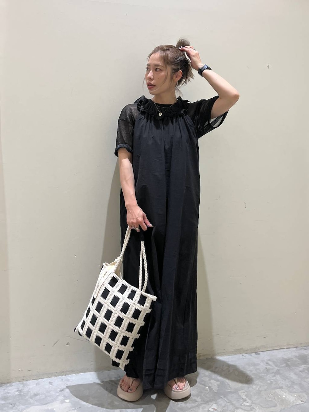 ベージュ系のサンダル、ブラック系のワンピース、ブラック系のトートバッグを着用したレディースの春コーディネートの4枚目の写真