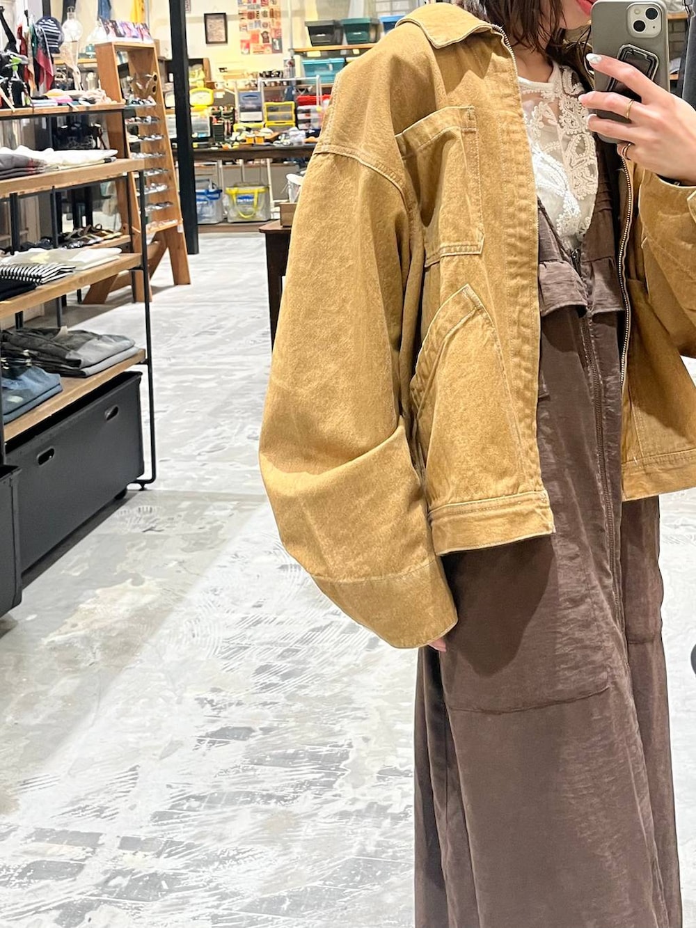 ブラウン系のジャンパースカート、ホワイト系のトートバッグ、ブラウン系のデニムジャケットを着用したレディースの春コーディネートの2枚目の写真