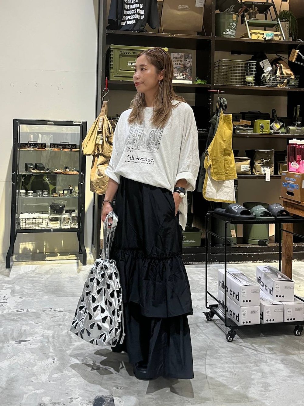 ベージュ系のTシャツ/カットソー、その他のトートバッグ、ブラック系のスカートを着用したレディースの夏コーディネートの3枚目の写真