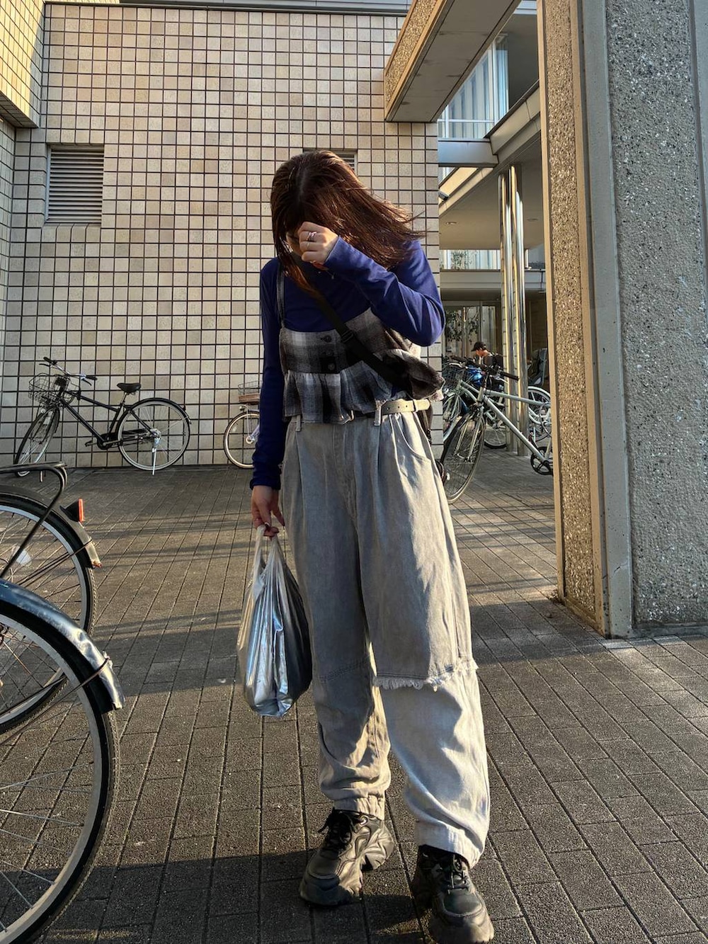 グレー系のデニムパンツ、ホワイト系のシャツ/ブラウス、ブラック系のキャミソールを着用したレディースの秋コーディネートの2枚目の写真