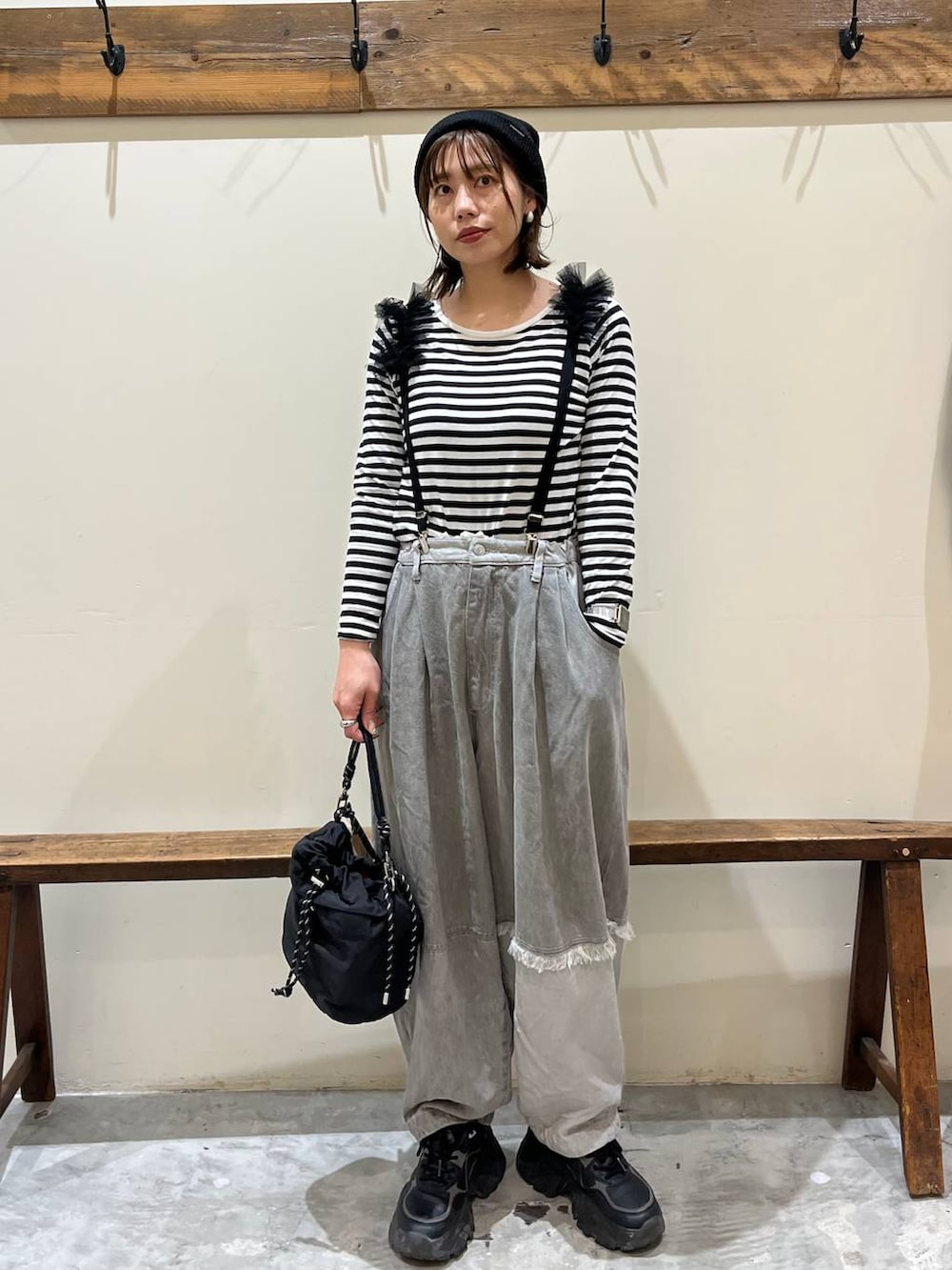 グレー系のデニムパンツ、ブラック系のショルダーバッグ、ブラック系のサスペンダーを着用したレディースの冬コーディネートの4枚目の写真
