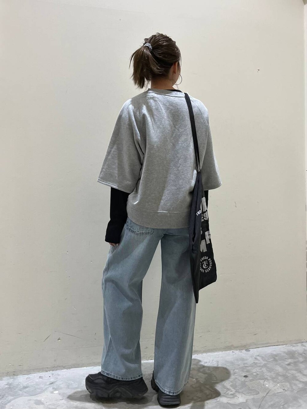 グレー系のトートバッグ、グレー系のTシャツ/カットソー、ブルー系のデニムパンツを着用したレディースの春コーディネートの4枚目の写真