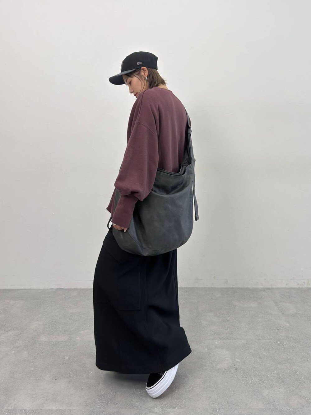 ブラック系のスカート、ブラック系のショルダーバッグ、レッド系のスウェットを着用したレディースの夏コーディネートの8枚目の写真