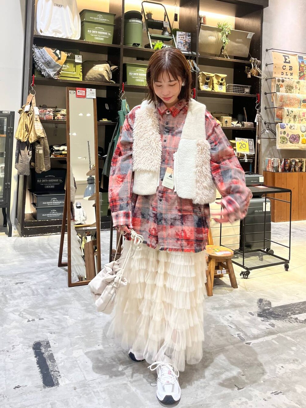 ホワイト系のスニーカー、レッド系のシャツ/ブラウス、ベージュ系のベストを着用したレディースの秋コーディネートの7枚目の写真