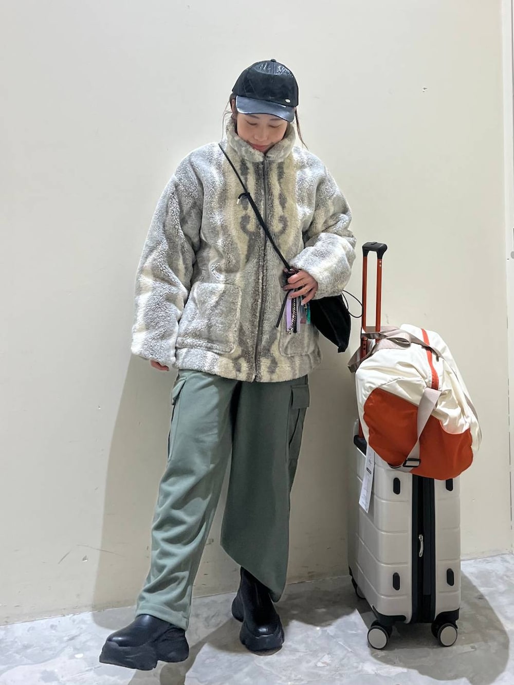 グレー系のブルゾン、ブラック系のショルダーバッグ、ブラック系のブーツを着用したレディースの冬コーディネートの2枚目の写真