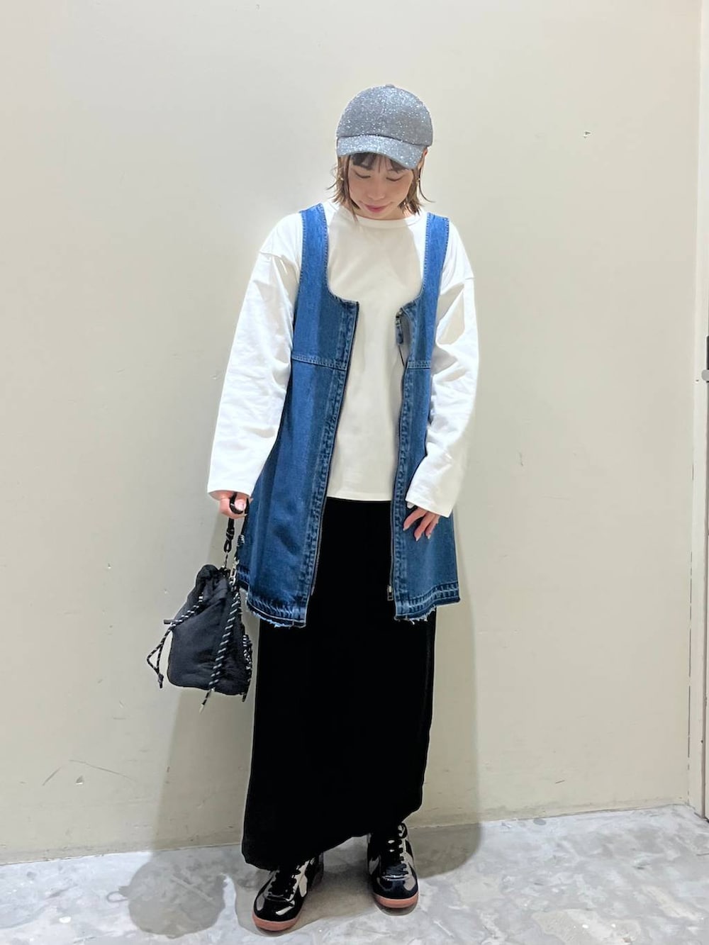 ブラック系のスカート、ブルー系のドレス、シルバー系のスニーカーを着用したレディースの冬コーディネートの3枚目の写真