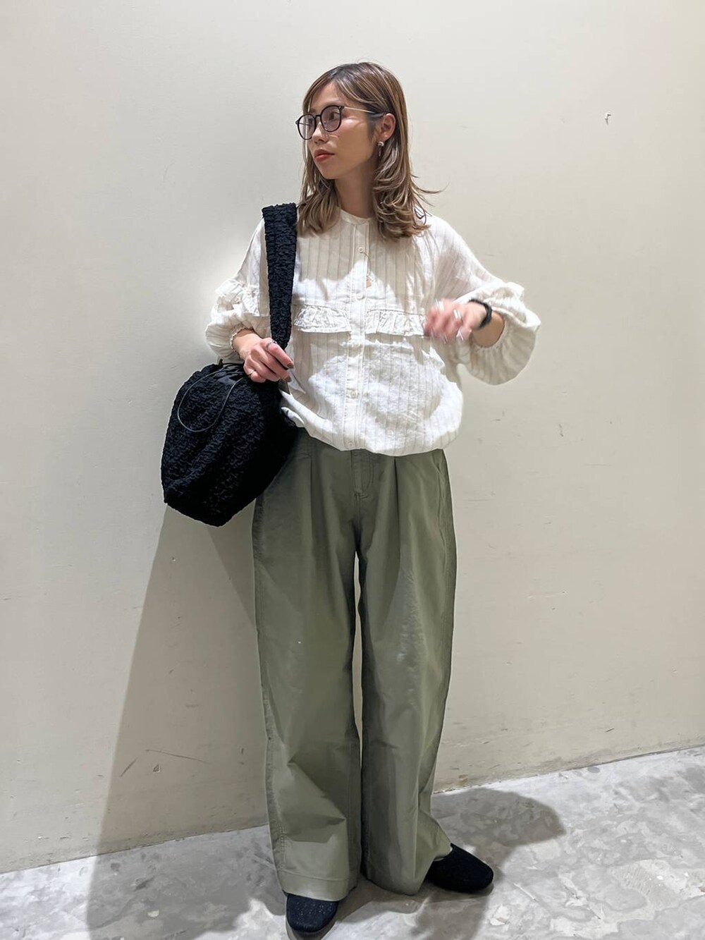 ブラック系のショルダーバッグ、ブラック系のその他シューズ、ベージュ系のシャツ/ブラウスを着用したレディースの春コーディネートの6枚目の写真