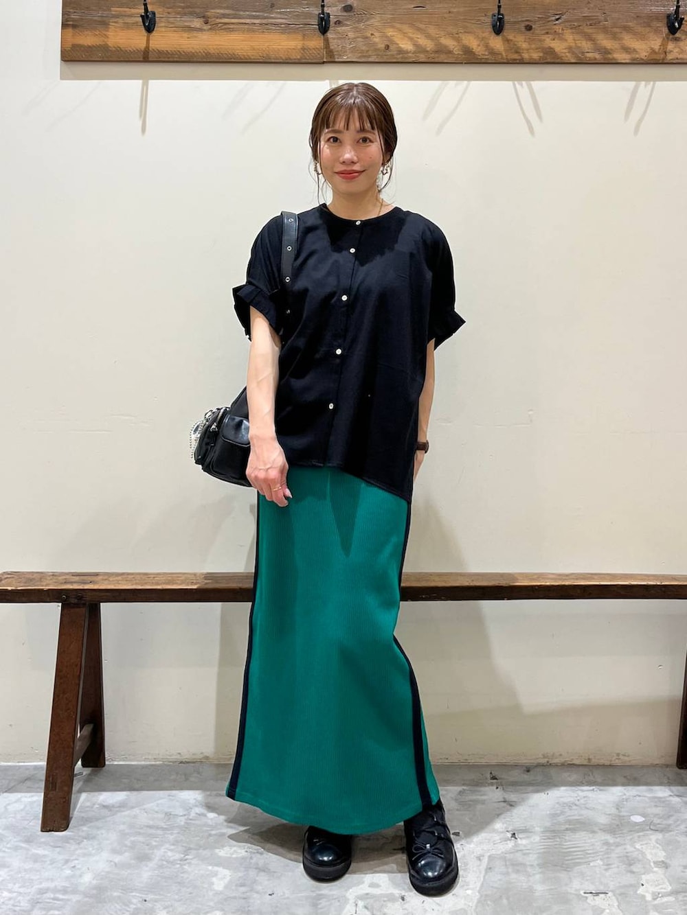 グリーン系のスカート、ブラック系のショルダーバッグ、ブラック系のバレエシューズを着用したレディースの春コーディネートの8枚目の写真