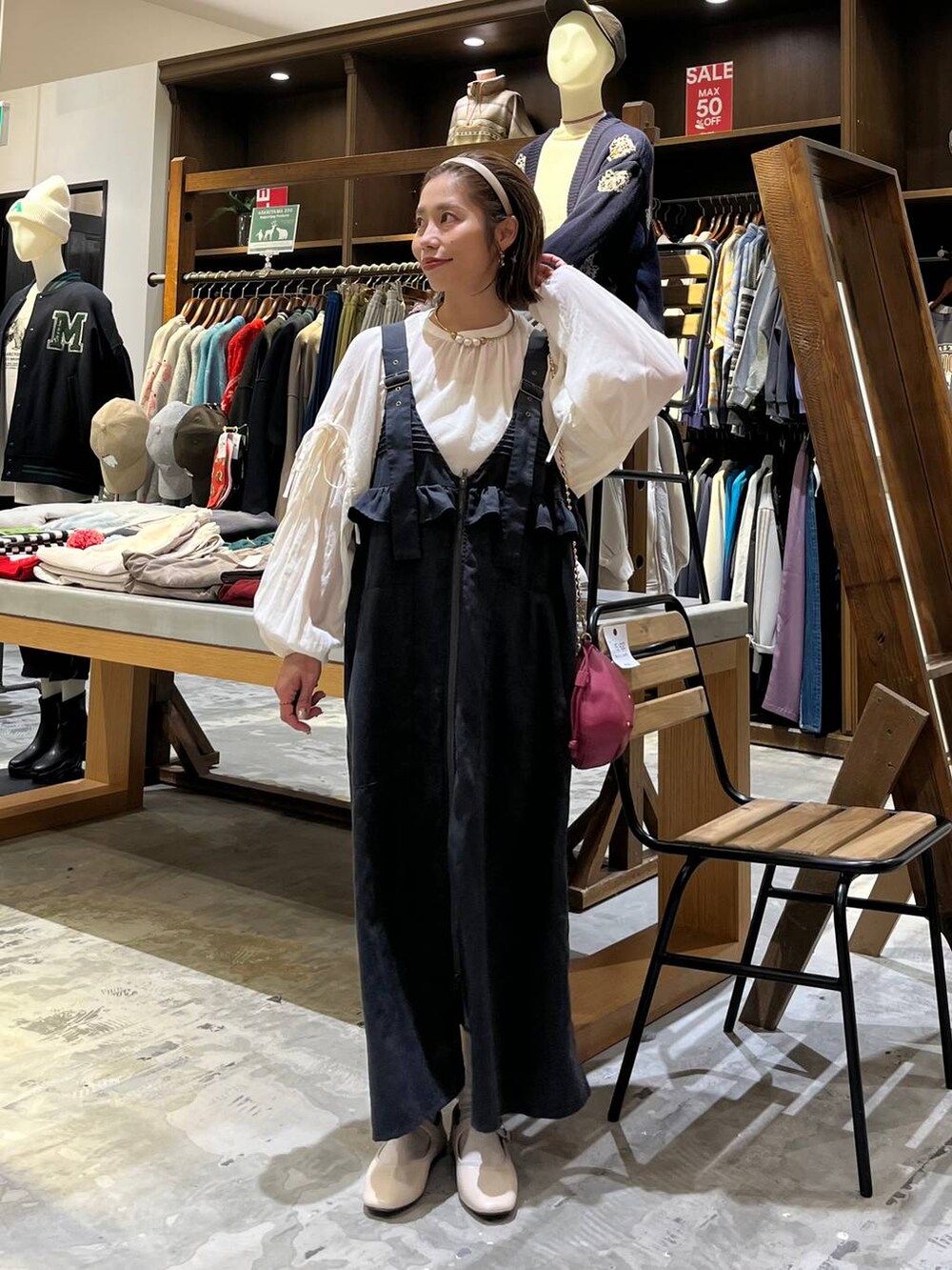 グレー系のジャンパースカート、ホワイト系のパンプス、ホワイト系のシャツ/ブラウスを着用したレディースの冬コーディネートの7枚目の写真