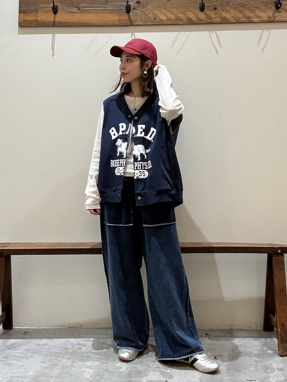 ゴールド系のスニーカー、ベージュ系のTシャツ/カットソー、ブルー系のベストを着用したレディースの冬コーディネートの3枚目の写真