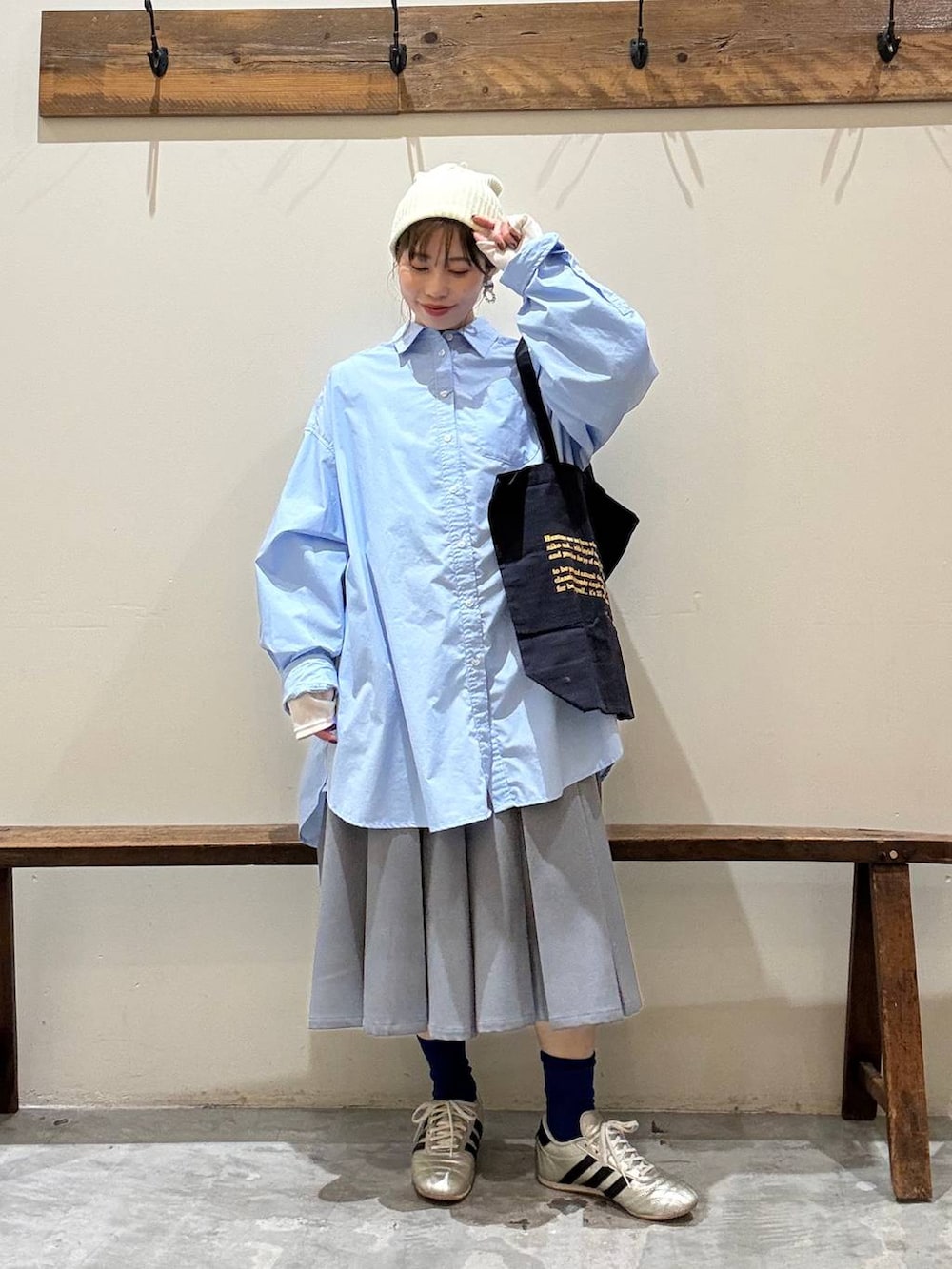 ブルー系のトートバッグ、ゴールド系のスニーカー、ベージュ系のTシャツ/カットソーを着用したレディースの冬コーディネートの3枚目の写真