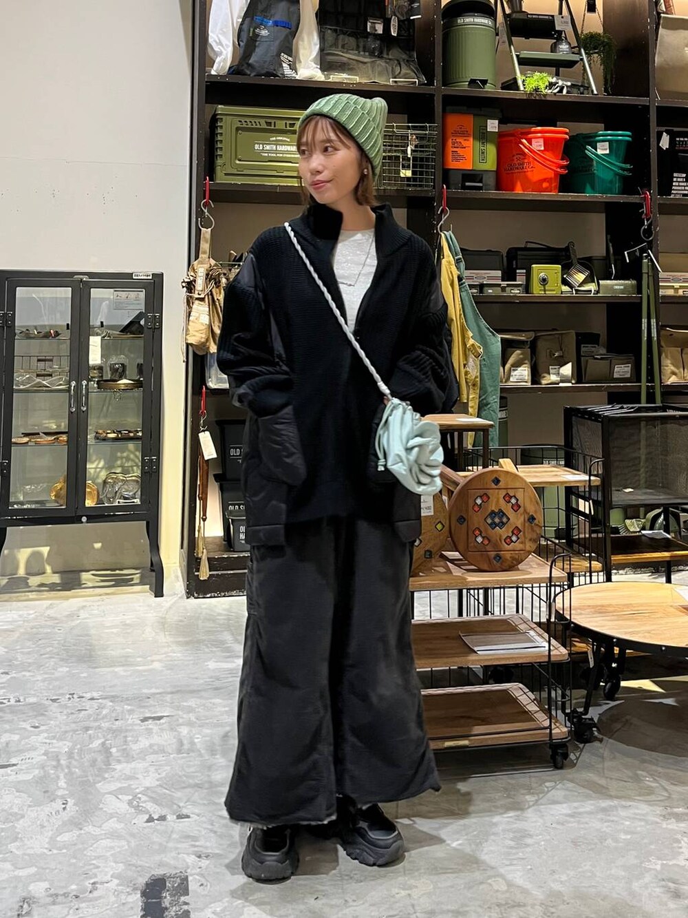 グレー系のスカート、グレー系のTシャツ/カットソー、ブラック系のブルゾンを着用したレディースの冬コーディネートの5枚目の写真