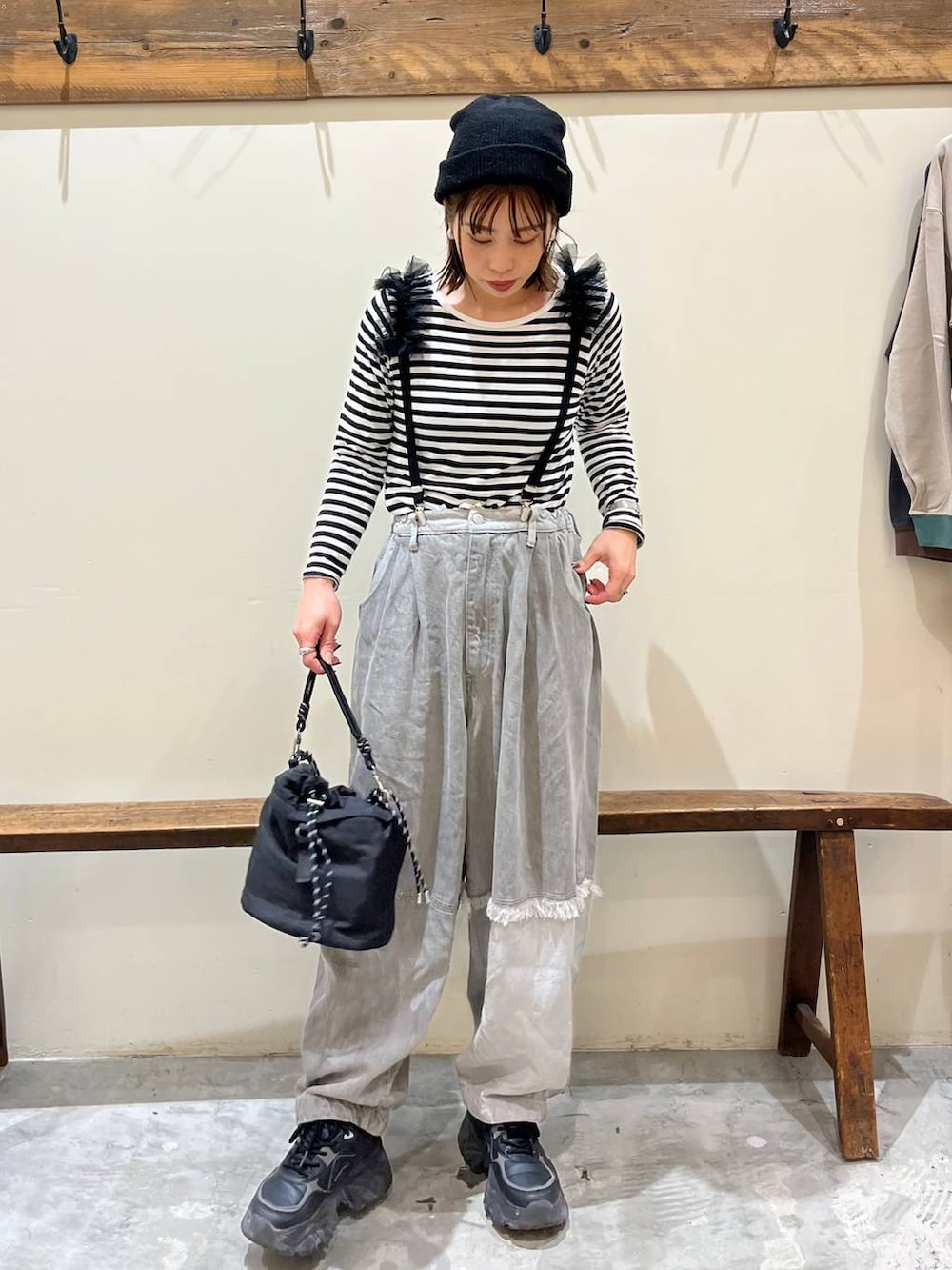 グレー系のデニムパンツ、ブラック系のショルダーバッグ、ブラック系のサスペンダーを着用したレディースの冬コーディネートの2枚目の写真