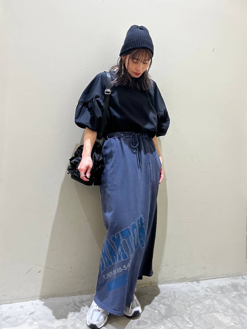 ブラック系のショルダーバッグ、ブルー系のスカート、ブラック系のシャツ/ブラウスを着用したレディースの春コーディネートの7枚目の写真