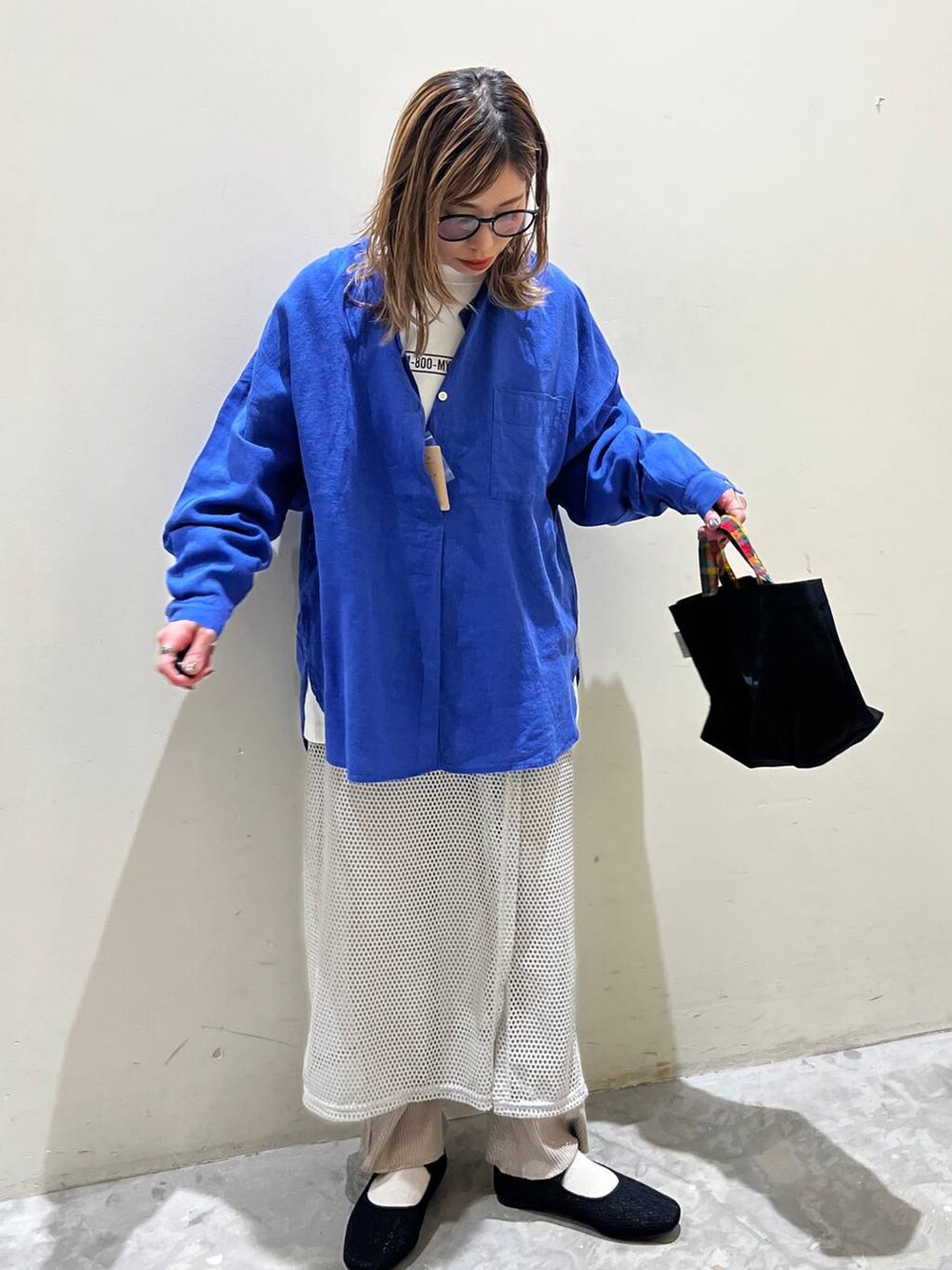 グレー系のスカート、ブラック系のその他シューズ、ブラック系のトートバッグを着用したレディースの春コーディネートの5枚目の写真