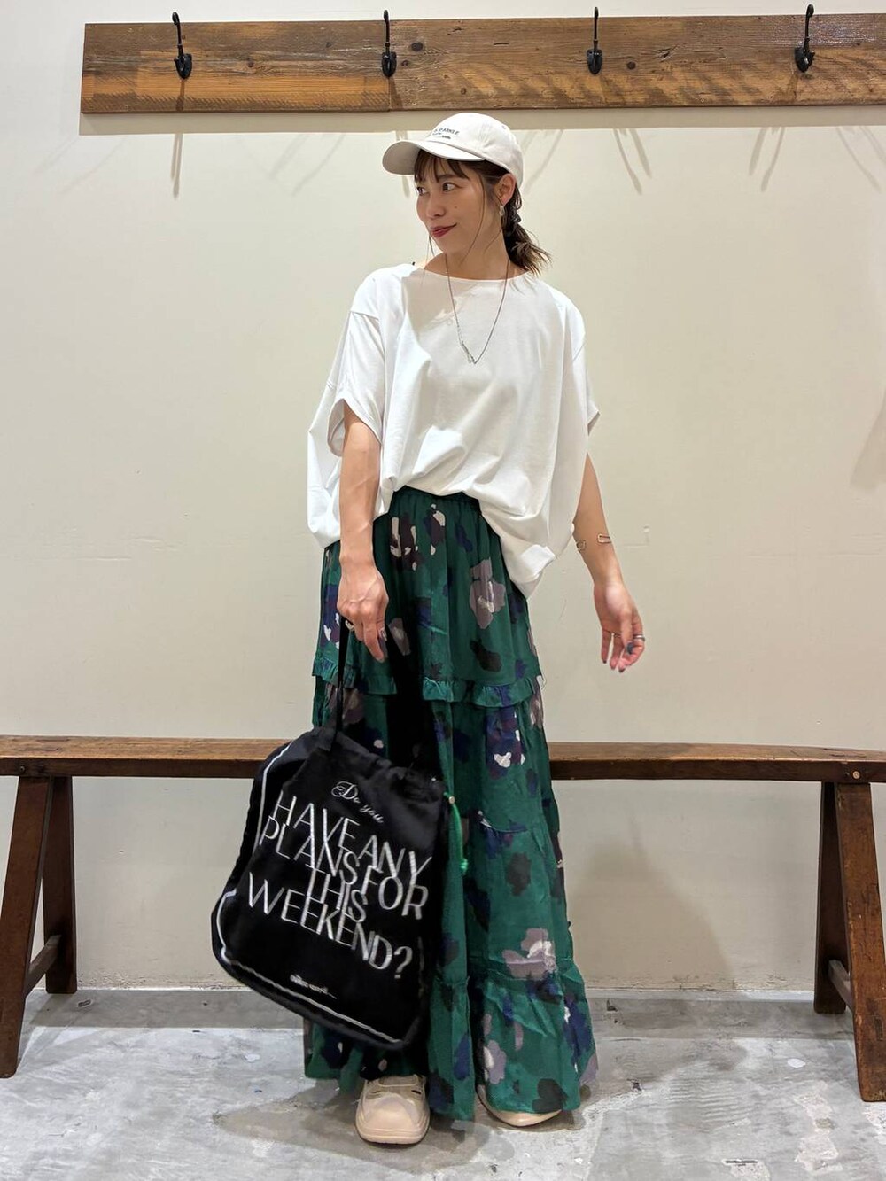 ブラック系のトートバッグ、グリーン系のスカート、ベージュ系のサンダルを着用したレディースの夏コーディネートの2枚目の写真
