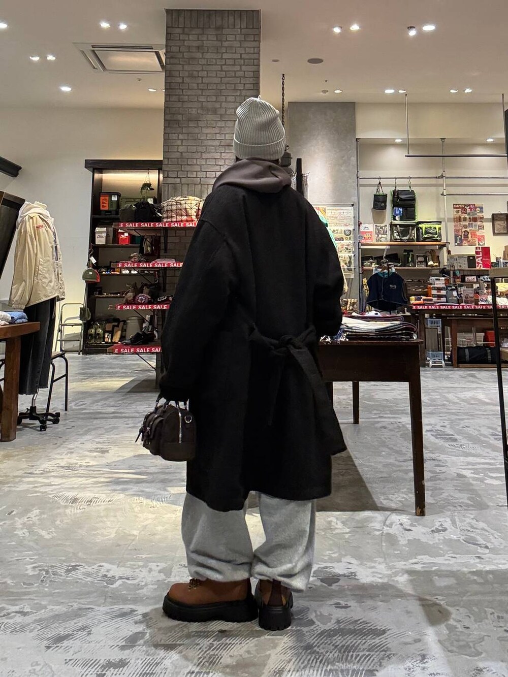 ブラウン系のボストンバッグ、ブラウン系のダウンジャケット/コート、イエロー系のその他シューズを着用したレディースの冬コーディネートの2枚目の写真