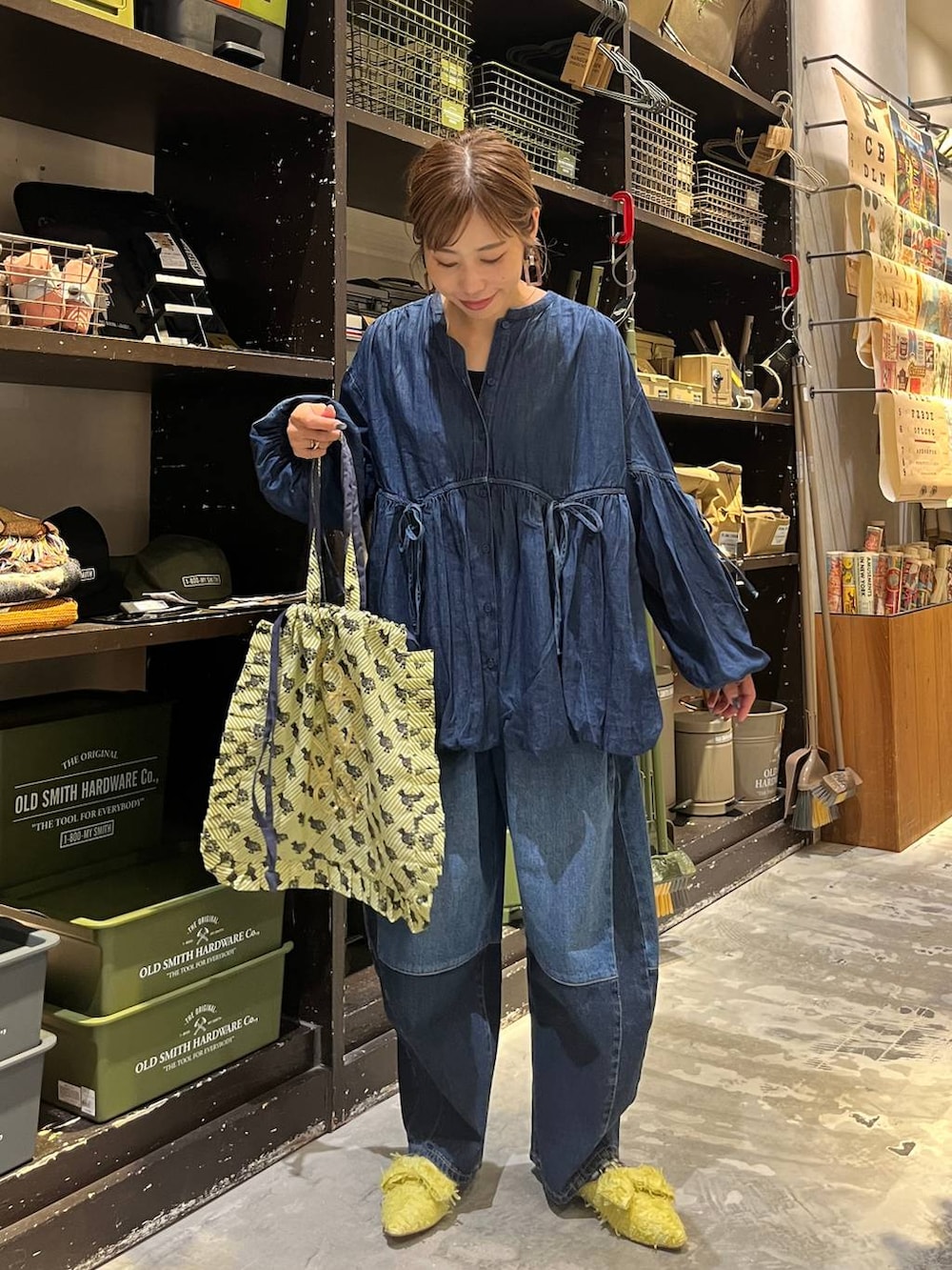 ベージュ系のトートバッグ、ブルー系のデニムパンツ、イエロー系のバレエシューズを着用したレディースの秋コーディネートの6枚目の写真