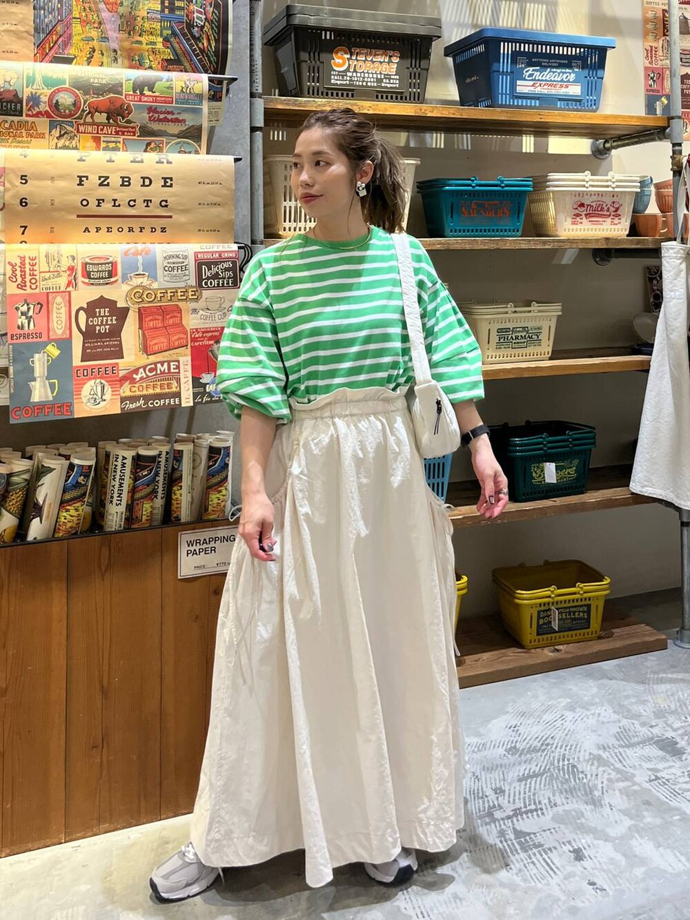 ベージュ系のスカート、ホワイト系のショルダーバッグ、グリーン系のTシャツ/カットソーを着用したレディースの春コーディネートの6枚目の写真