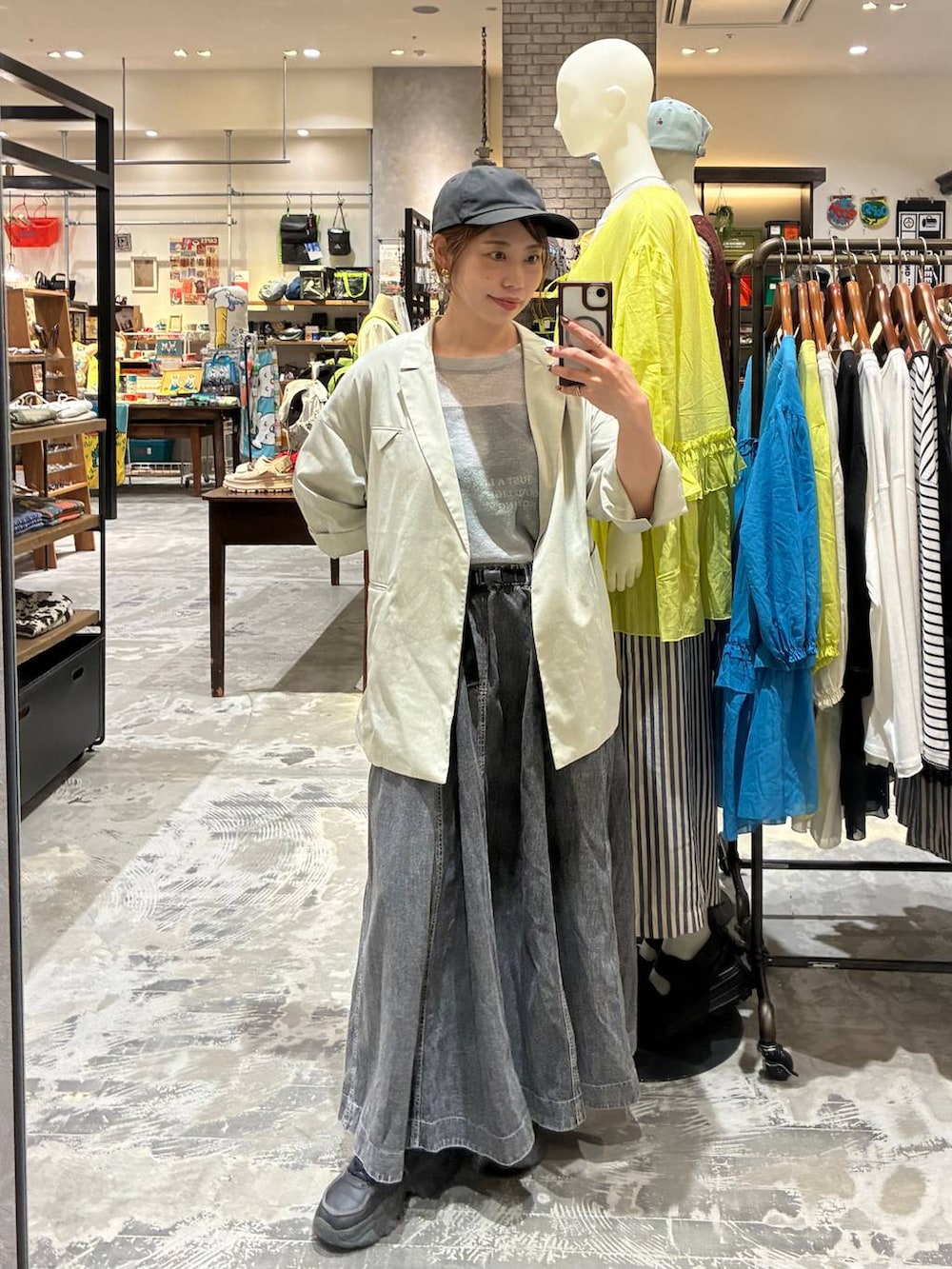 グレー系のスカート、ベージュ系のテーラードジャケット、グレー系のTシャツ/カットソーを着用したレディースの春コーディネートの2枚目の写真