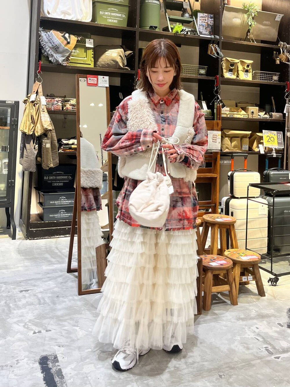 ホワイト系のスニーカー、レッド系のシャツ/ブラウス、ベージュ系のベストを着用したレディースの秋コーディネートの5枚目の写真