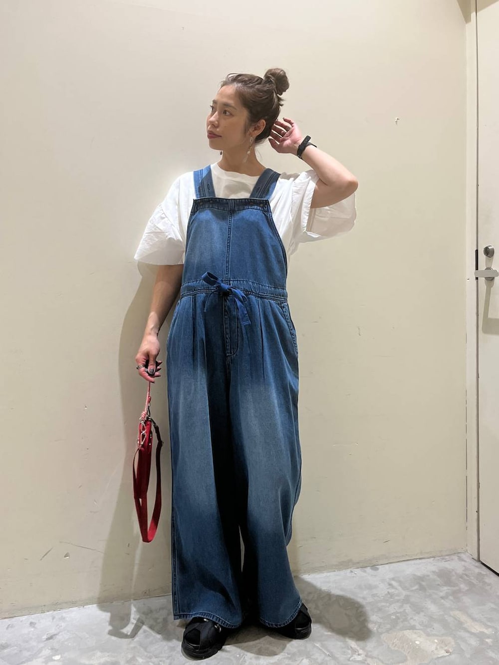 ホワイト系のTシャツ/カットソー、ブラック系のサンダル、レッド系のショルダーバッグを着用したレディースの春コーディネートの5枚目の写真