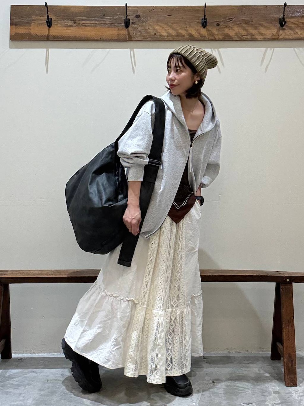 ベージュ系のスカート、ブラック系のショルダーバッグ、グレー系のパーカーを着用したレディースの秋コーディネートの10枚目の写真