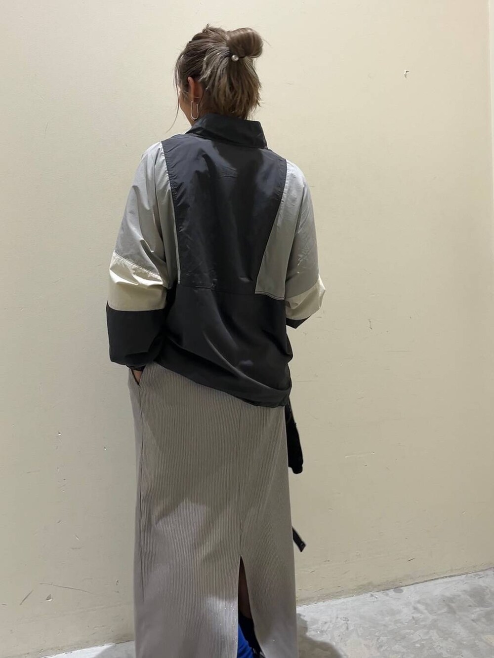 グレー系のナイロンジャケット、ブラック系のバックパック/リュック、グレー系のスカートを着用したレディースの春コーディネートの2枚目の写真