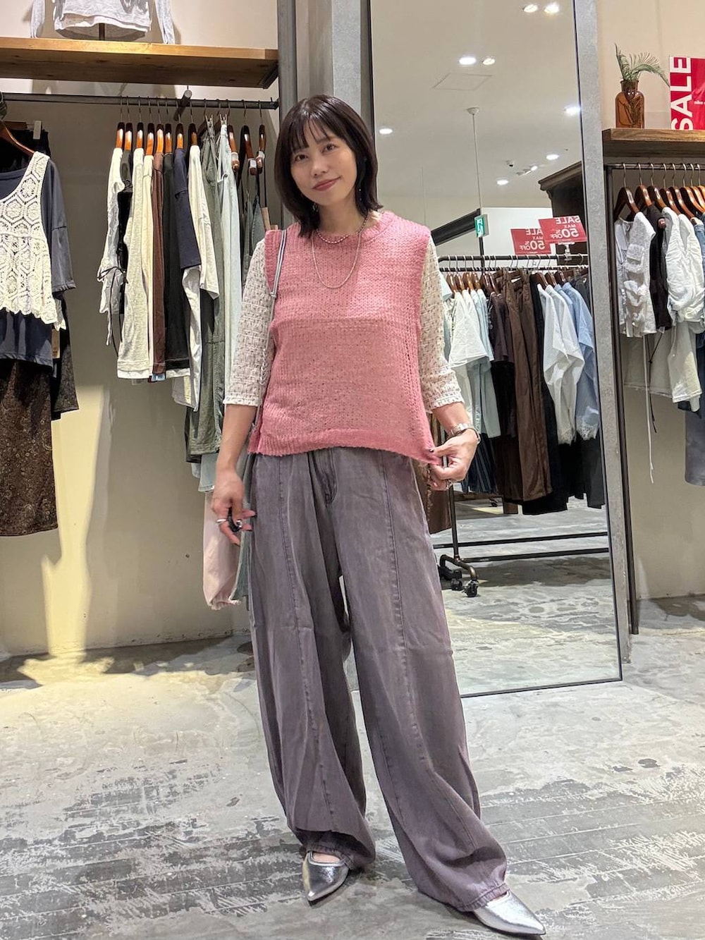 ピンク系のベスト、ベージュ系のTシャツ/カットソー、パープル系のデニムパンツを着用したレディースの夏コーディネートの7枚目の写真