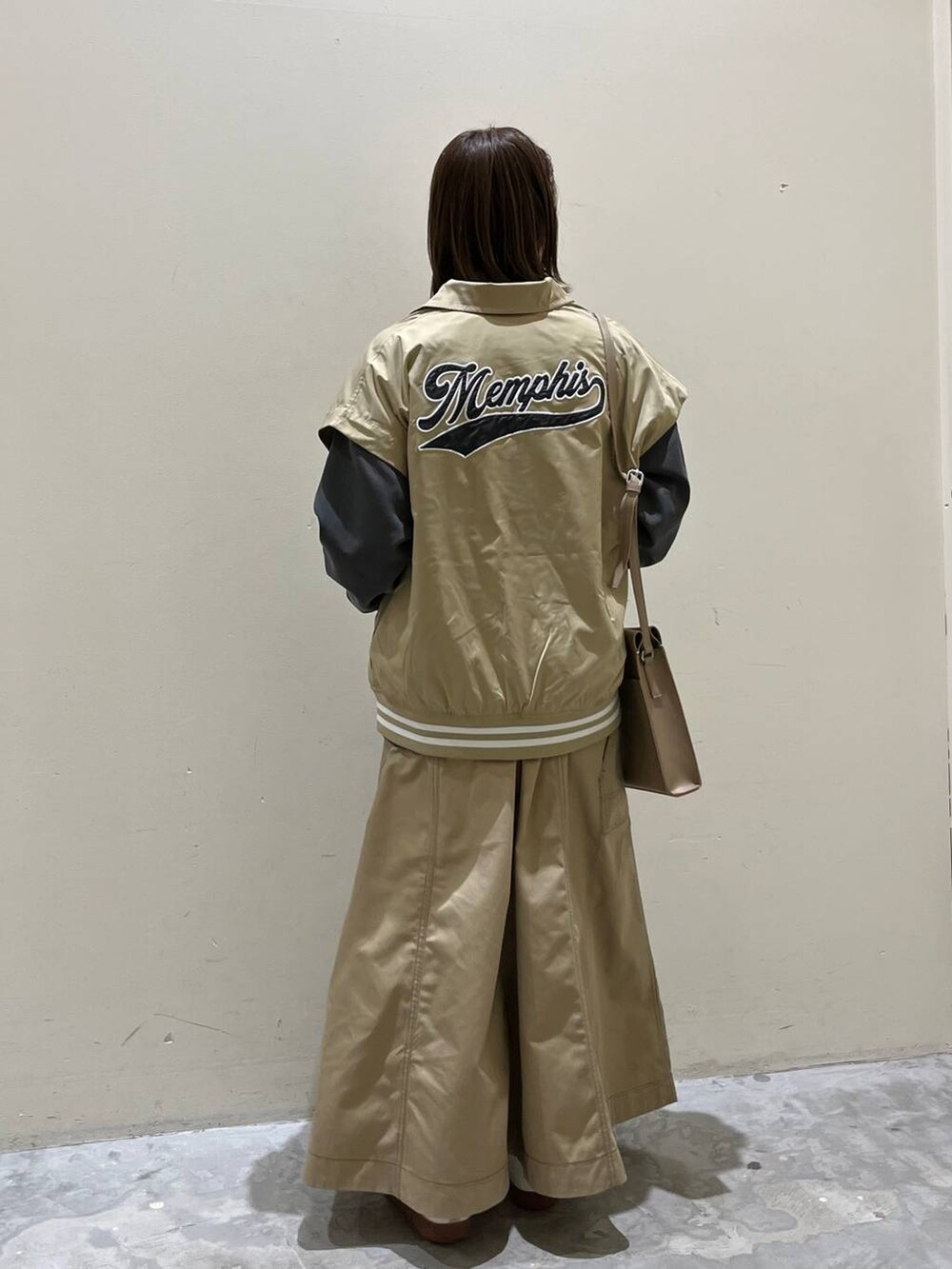 ベージュ系のスニーカー、ベージュ系のスタジャン、ベージュ系のスカートを着用したレディースの冬コーディネートの4枚目の写真