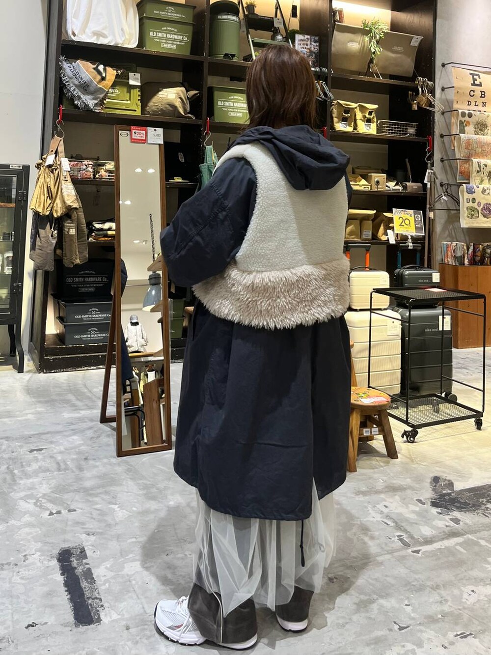 ホワイト系のスニーカー、ブラウン系のその他パンツ、ベージュ系のベストを着用したレディースの秋コーディネートの3枚目の写真
