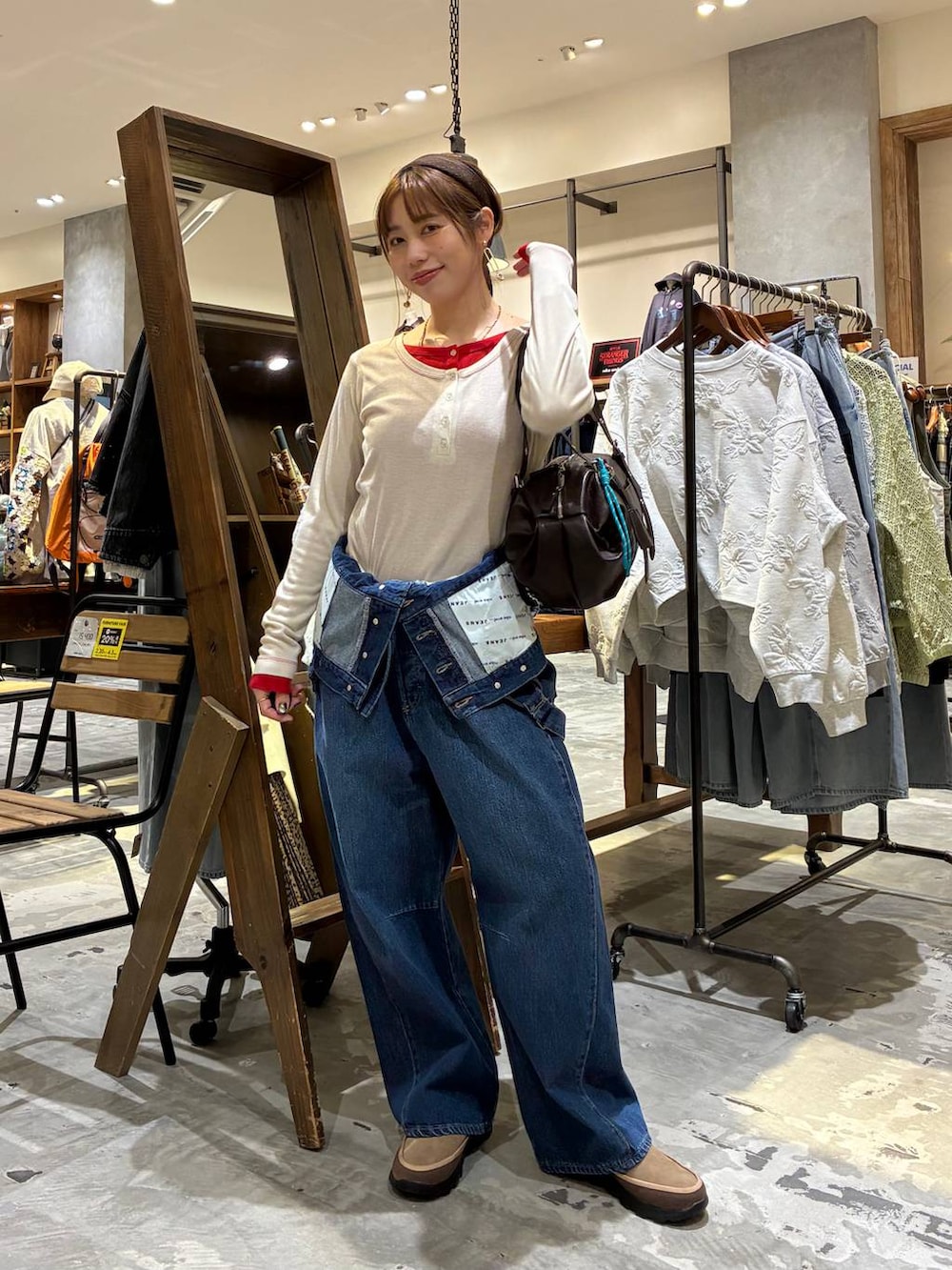 ブラウン系のボストンバッグ、ベージュ系のTシャツ/カットソー、ブルー系のサロペット/オーバーオールを着用したレディースの冬コーディネートの9枚目の写真