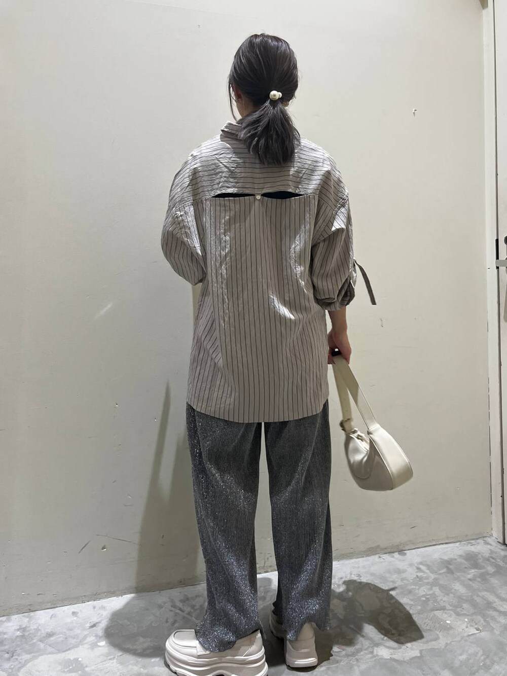 ベージュ系のショルダーバッグ、ベージュ系のローファー、グレー系のその他パンツを着用したレディースの春コーディネートの4枚目の写真