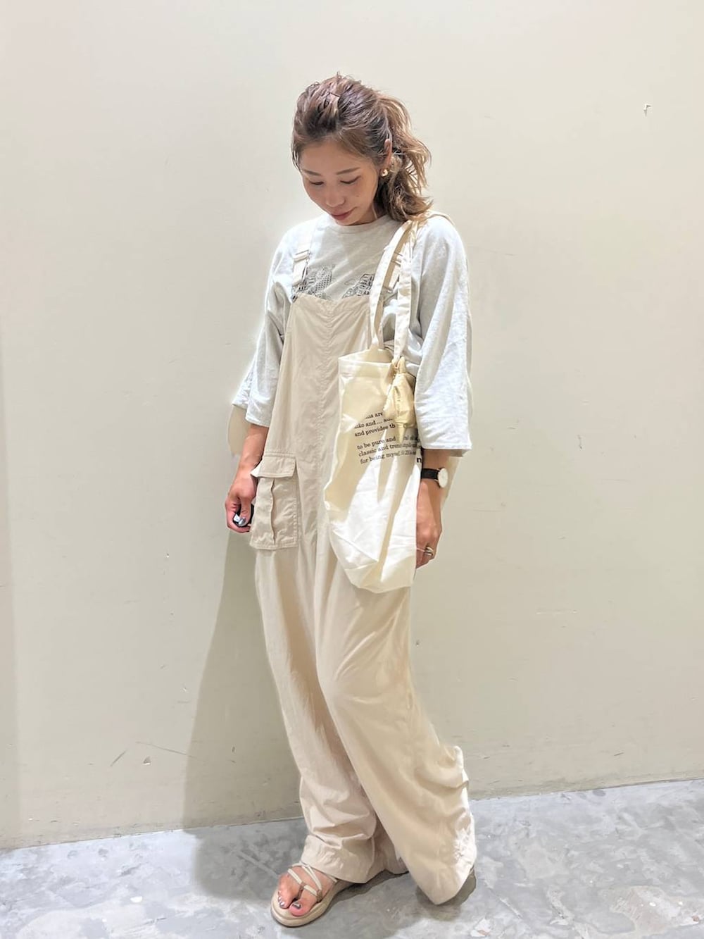ベージュ系のサロペット/オーバーオール、ベージュ系のTシャツ/カットソー、ベージュ系のサンダルを着用したレディースの夏コーディネートの4枚目の写真