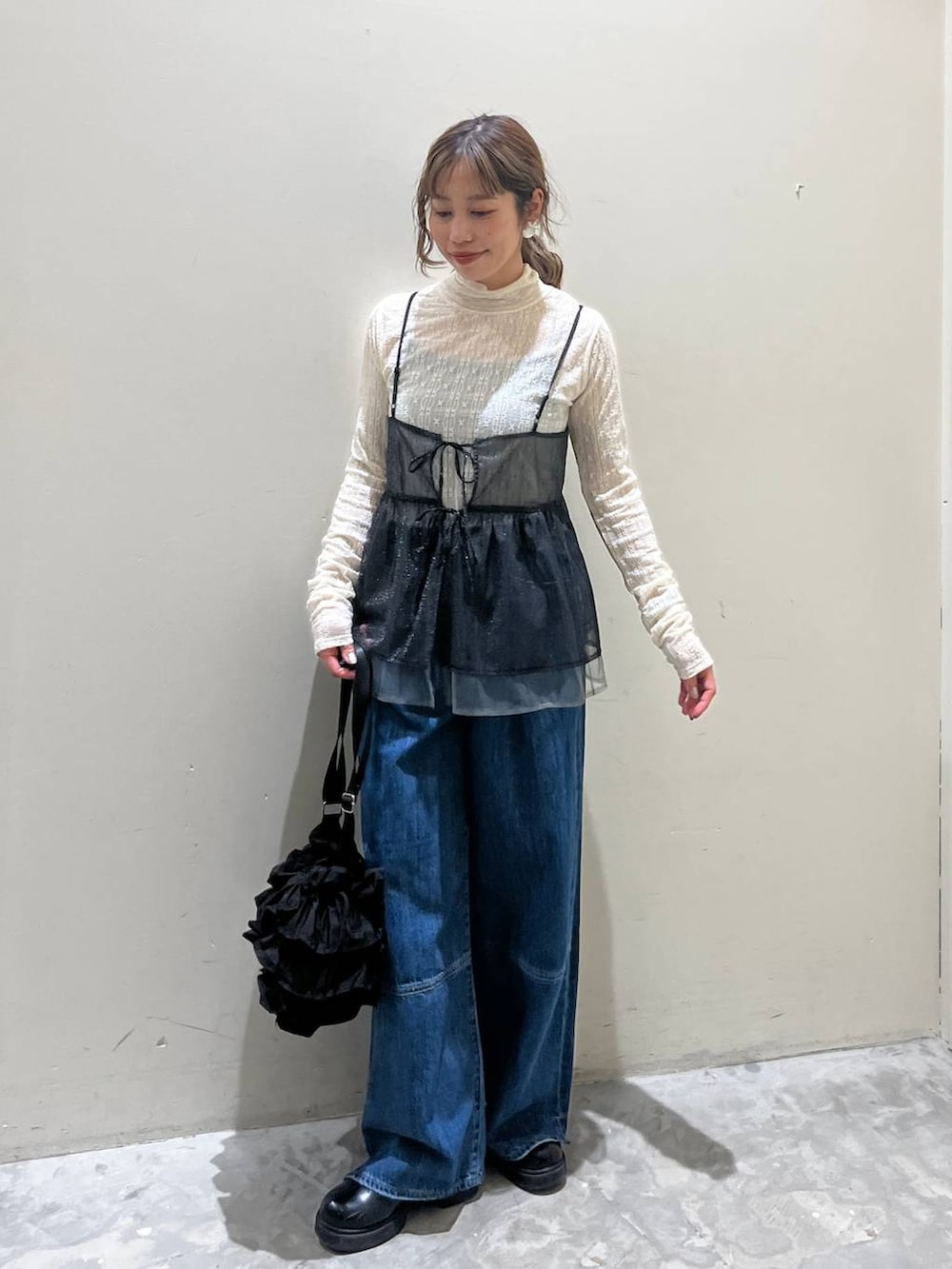 ブラック系のキャミソール、ブラック系のショルダーバッグ、ブラック系のブーツを着用したレディースの冬コーディネートの6枚目の写真