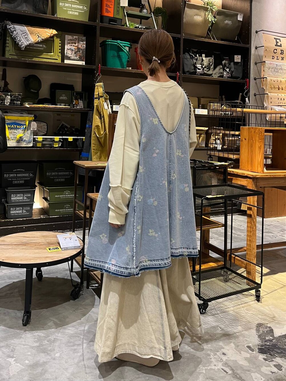 イエロー系のショルダーバッグ、ブルー系のドレス、ベージュ系のスニーカーを着用したレディースの冬コーディネートの4枚目の写真