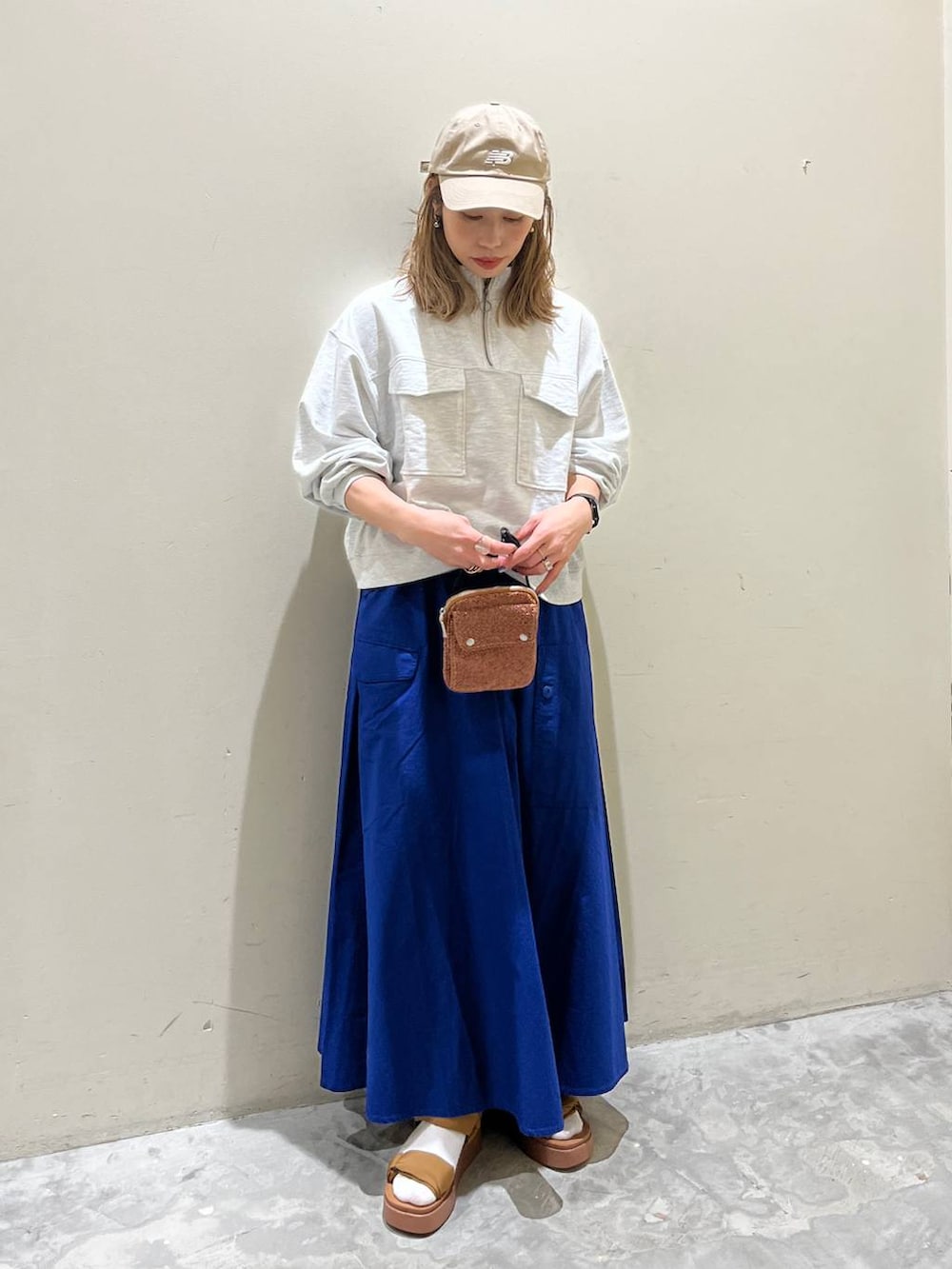 イエロー系のサンダル、ベージュ系のスウェット、オレンジ系のショルダーバッグを着用したレディースの春コーディネートの2枚目の写真